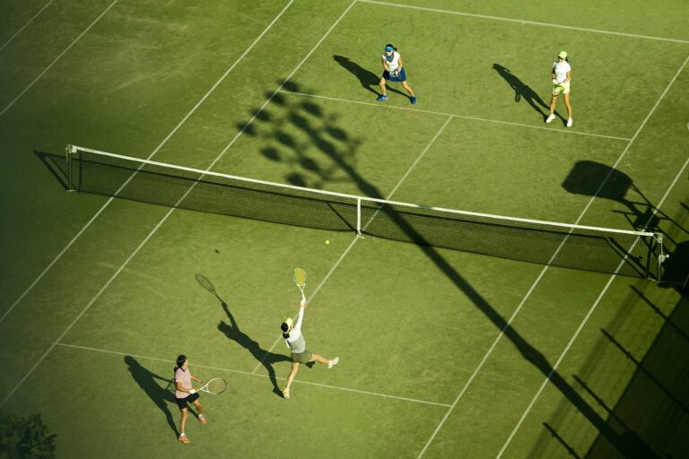 Tennis doubles match on a grass court, highlighting the sport's global popularity